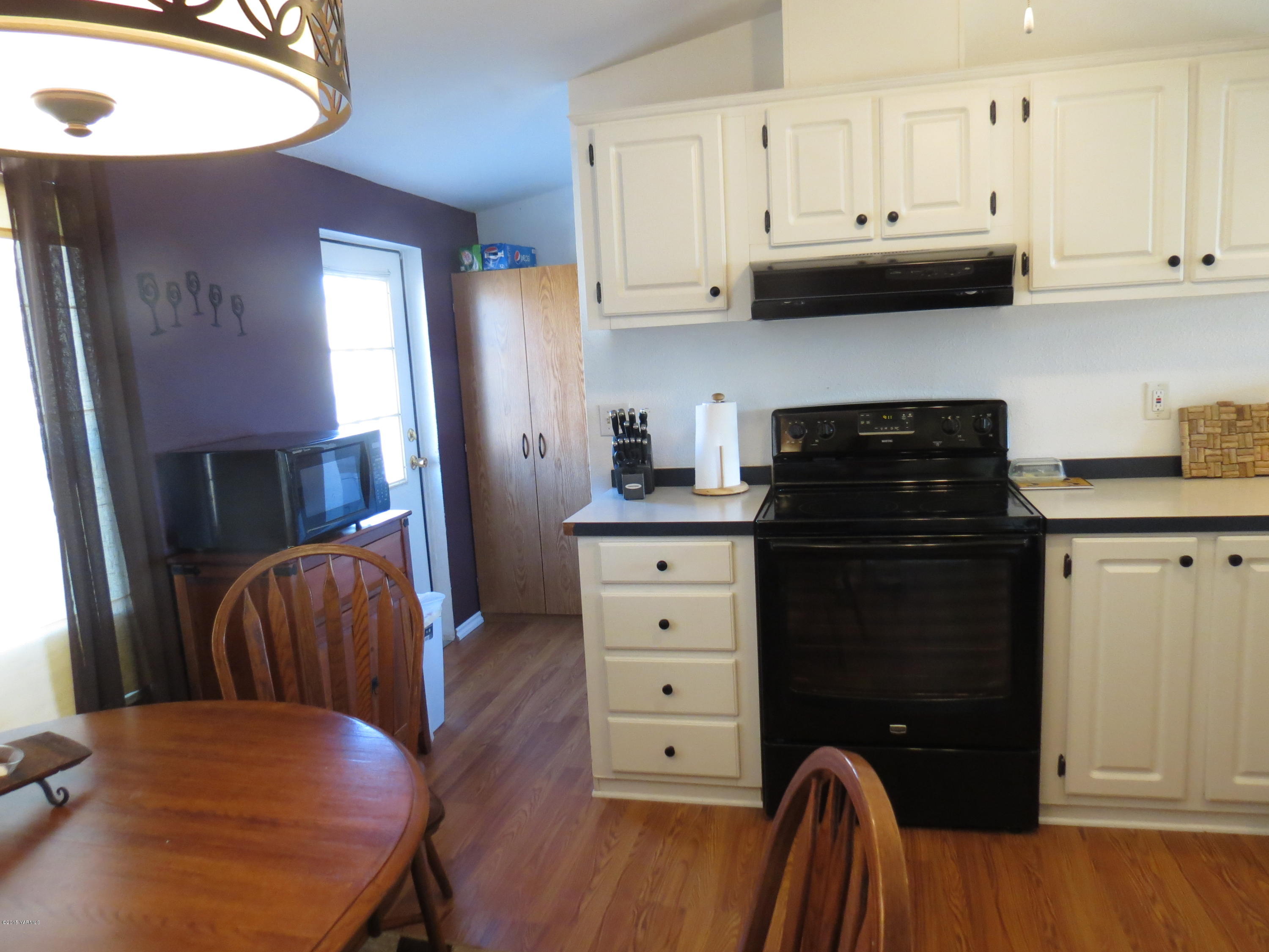 515 Burnham Road Yakima, WA 98908 - Photo 14 of 20 a kitchen with stainless steel appliances granite countertop a refrigerator a stove a sink dishwasher and white cabinets with wooden floor