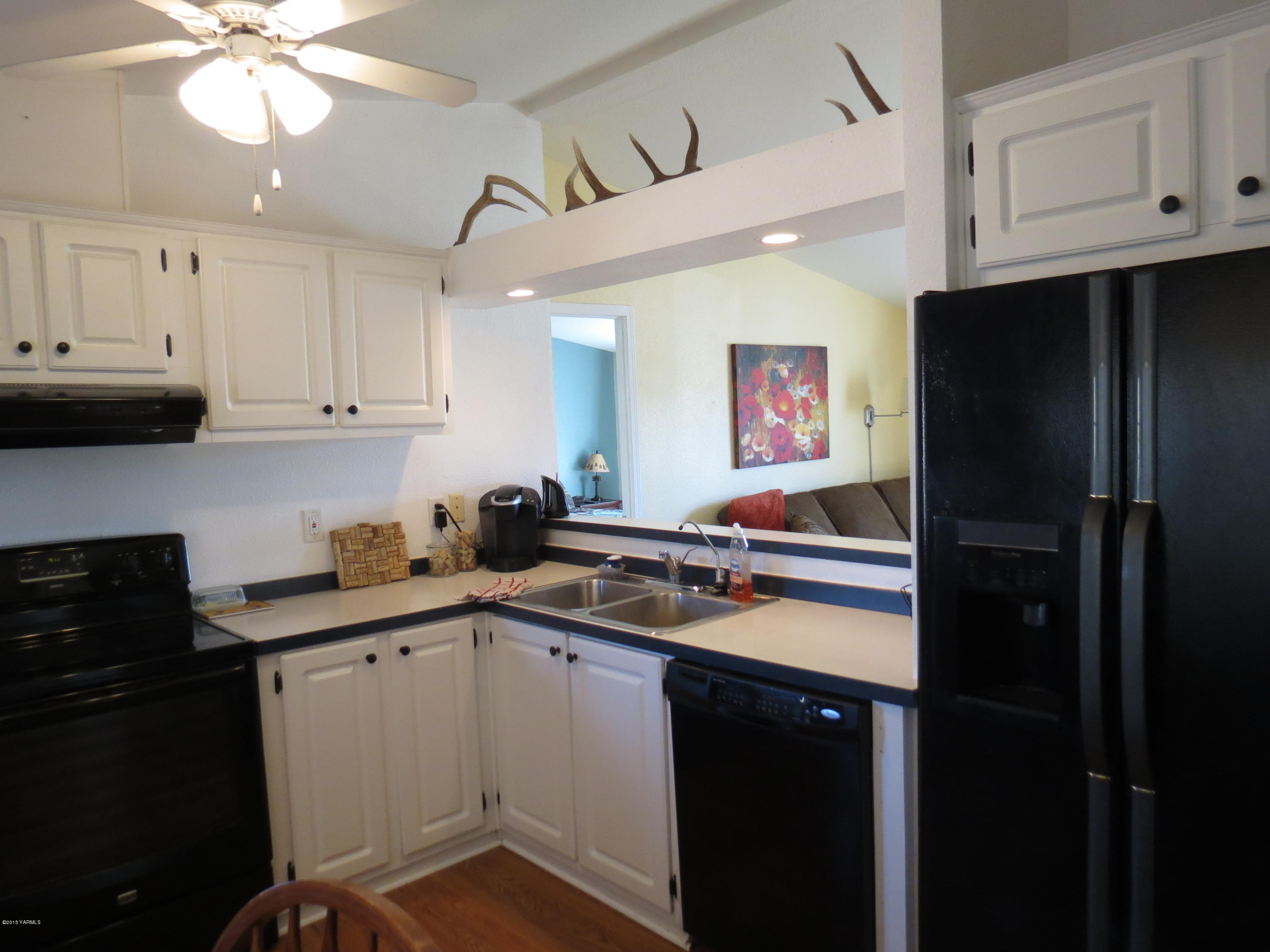 515 Burnham Road Yakima, WA 98908 - Photo 16 of 20 a kitchen with stainless steel appliances granite countertop a refrigerator a sink dishwasher and white cabinets with wooden floor