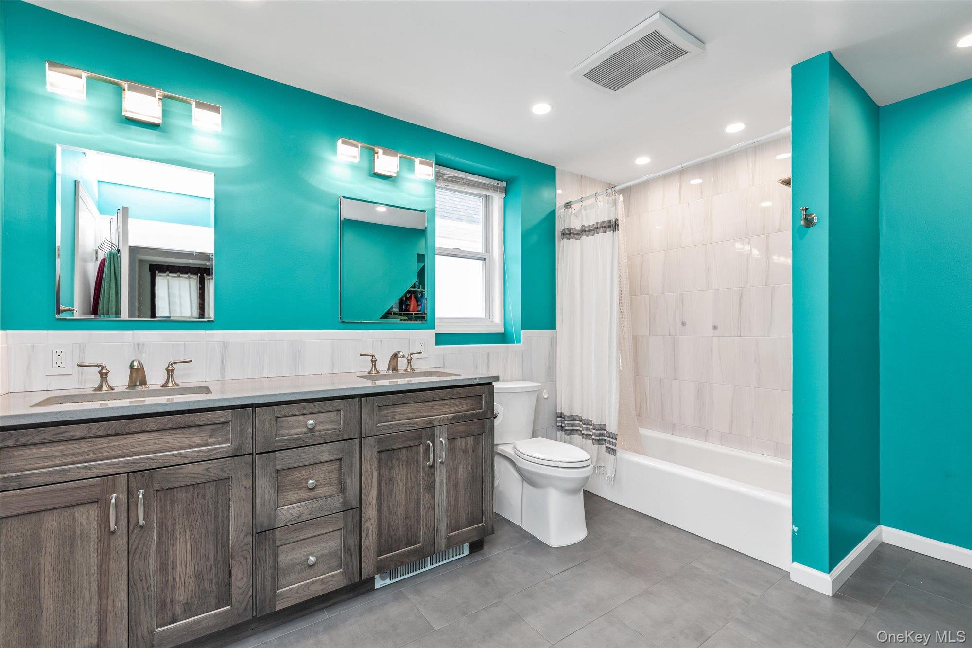 1894 Commonwealth Avenue Merrick, NY 11566 - Photo 15 of 22 a bathroom with a double vanity sink a mirror and a bathtub
