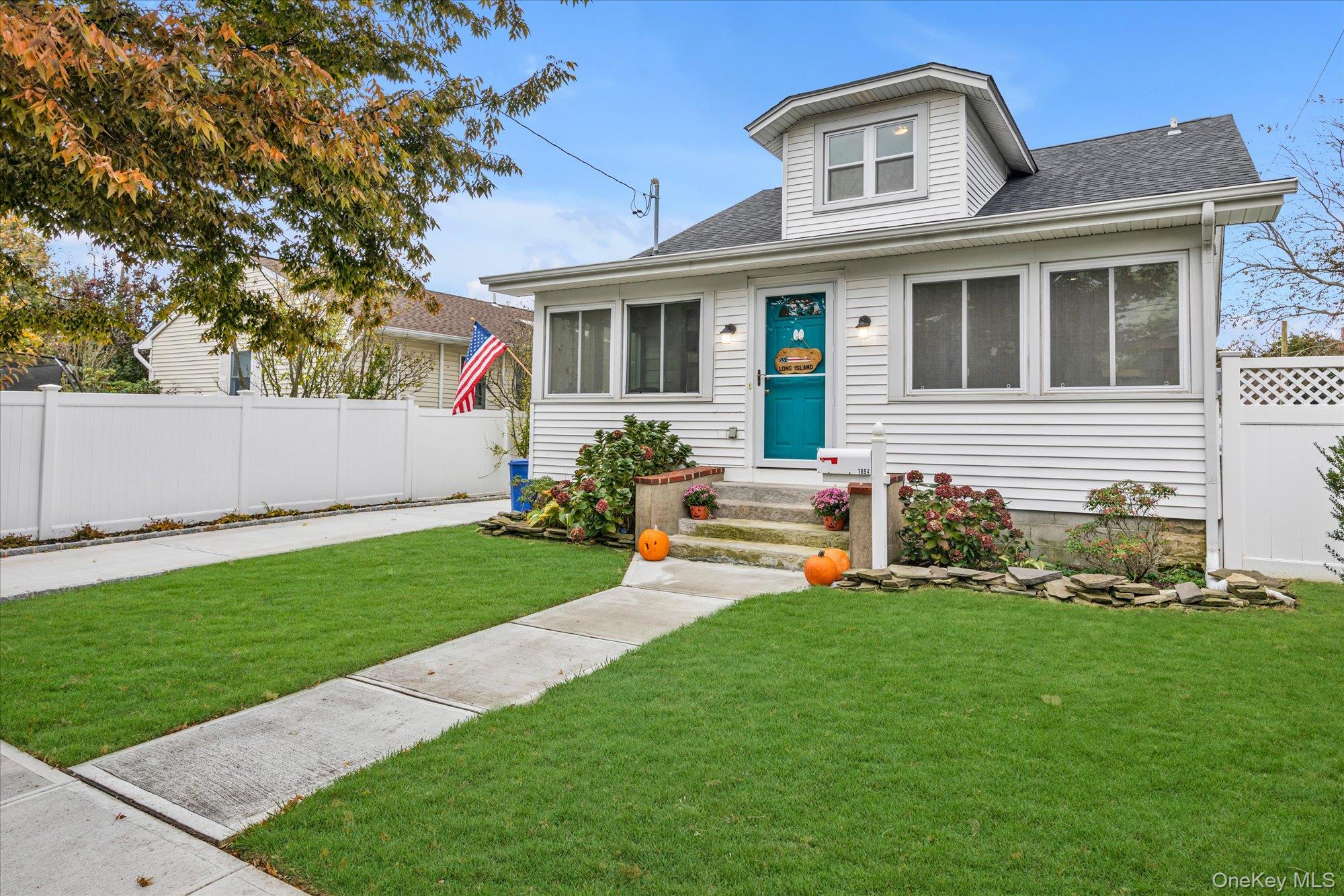 1894 Commonwealth Avenue Merrick, NY 11566 - Photo 3 of 22 a front view of a house with a garden and trees