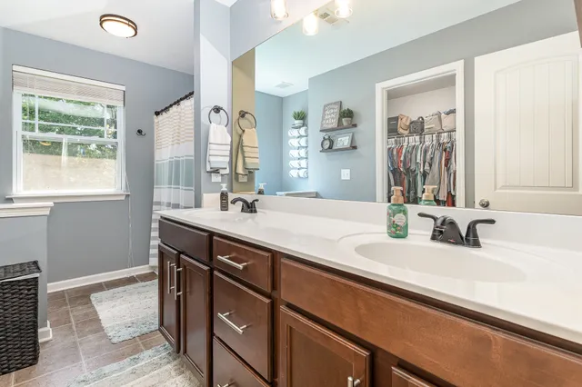 a bathroom with a double vanity sink window and a mirror