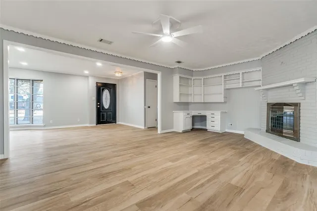 a view of an empty room with a fireplace and a window