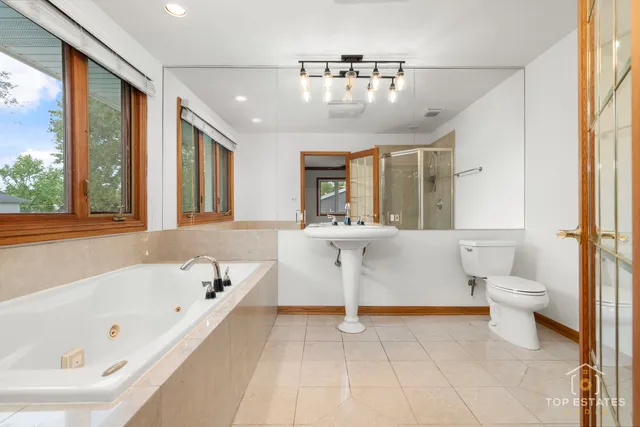 a spacious bathroom with a sink a large mirror and a bathtub
