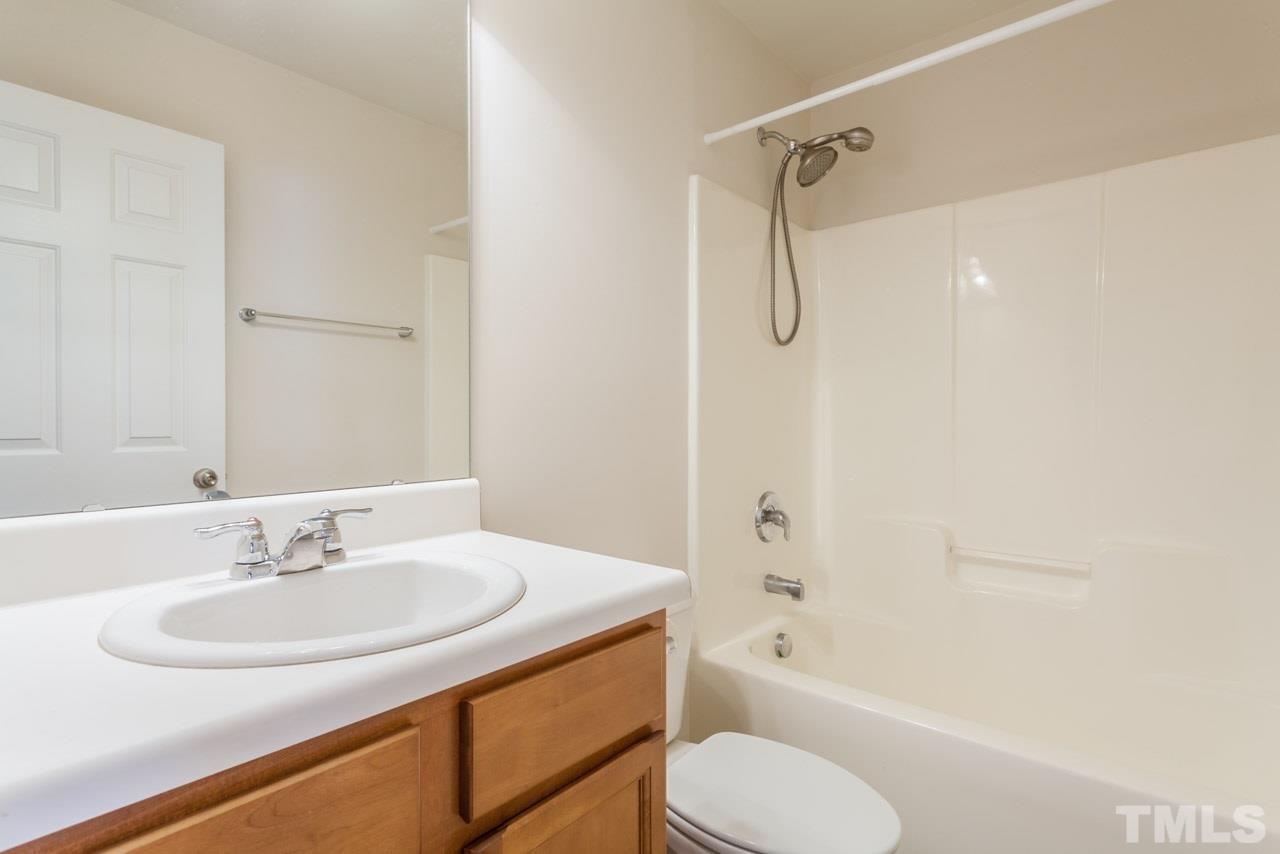 7006 Racine Way Raleigh, NC 27690 - Photo 12 of 24 a bathroom with a granite countertop sink toilet and shower