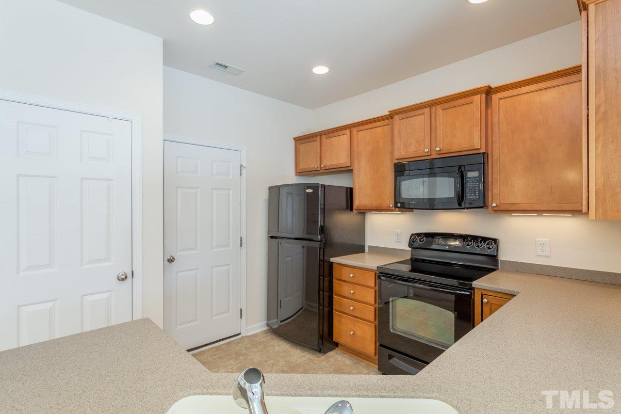 7006 Racine Way Raleigh, NC 27690 - Photo 18 of 24 a kitchen with a refrigerator and a stove top oven