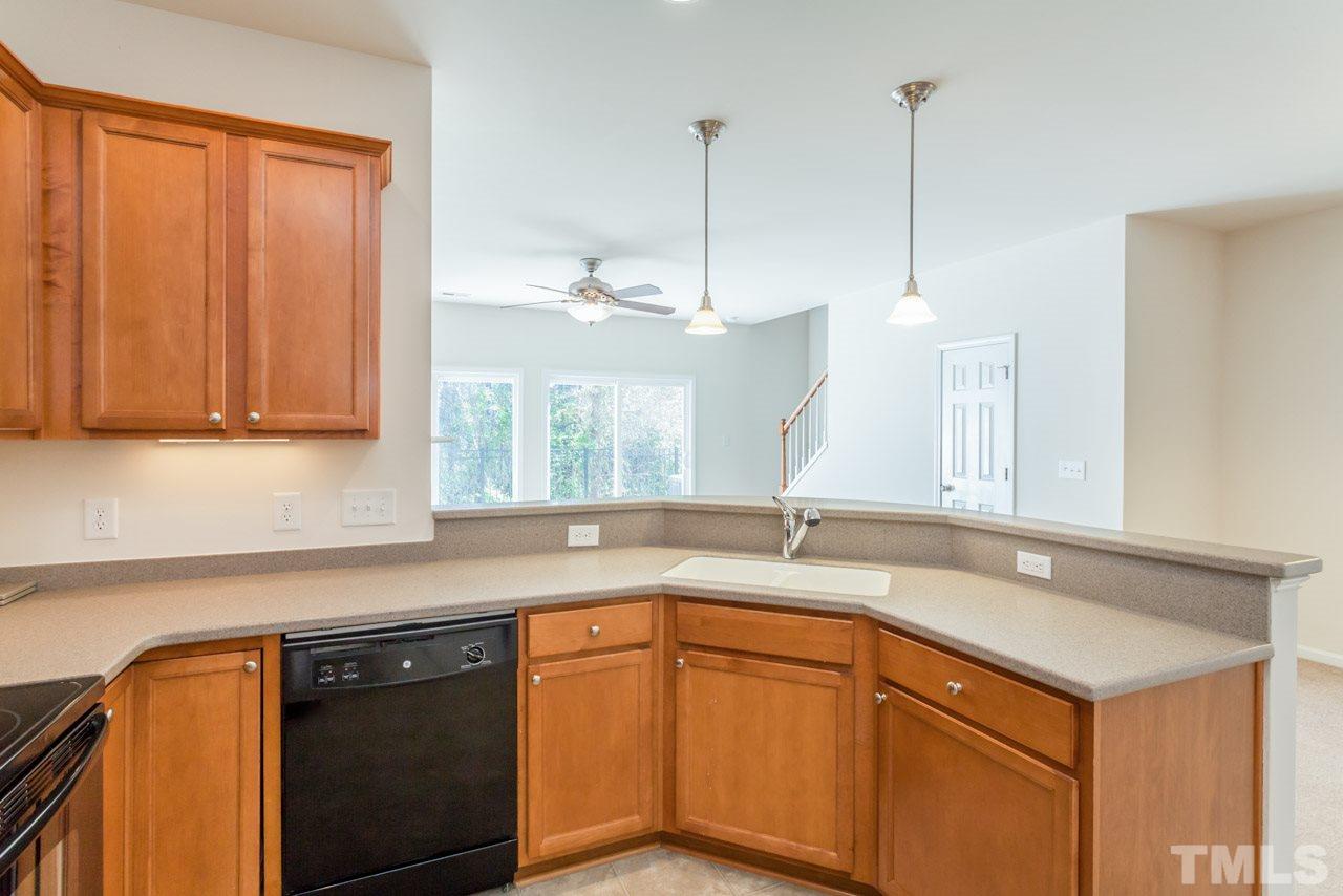 7006 Racine Way Raleigh, NC 27690 - Photo 19 of 24 a kitchen with stainless steel appliances granite countertop a sink a stove and a microwave