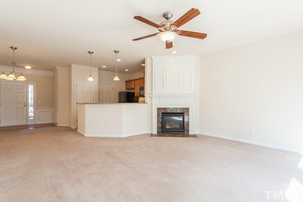 7006 Racine Way Raleigh, NC 27690 - Photo 20 of 24 an empty room with a kitchen and a ceiling fan