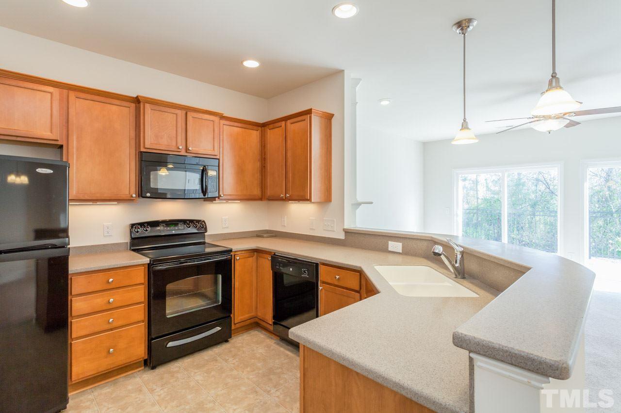 7006 Racine Way Raleigh, NC 27690 - Photo 3 of 24 a kitchen with a stove a sink and a refrigerator