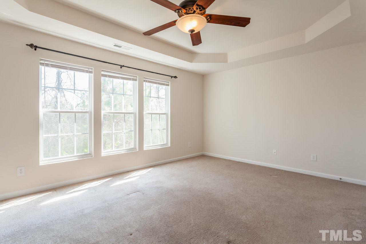 7006 Racine Way Raleigh, NC 27690 - Photo 23 of 24 an empty room with chandelier fan and windows
