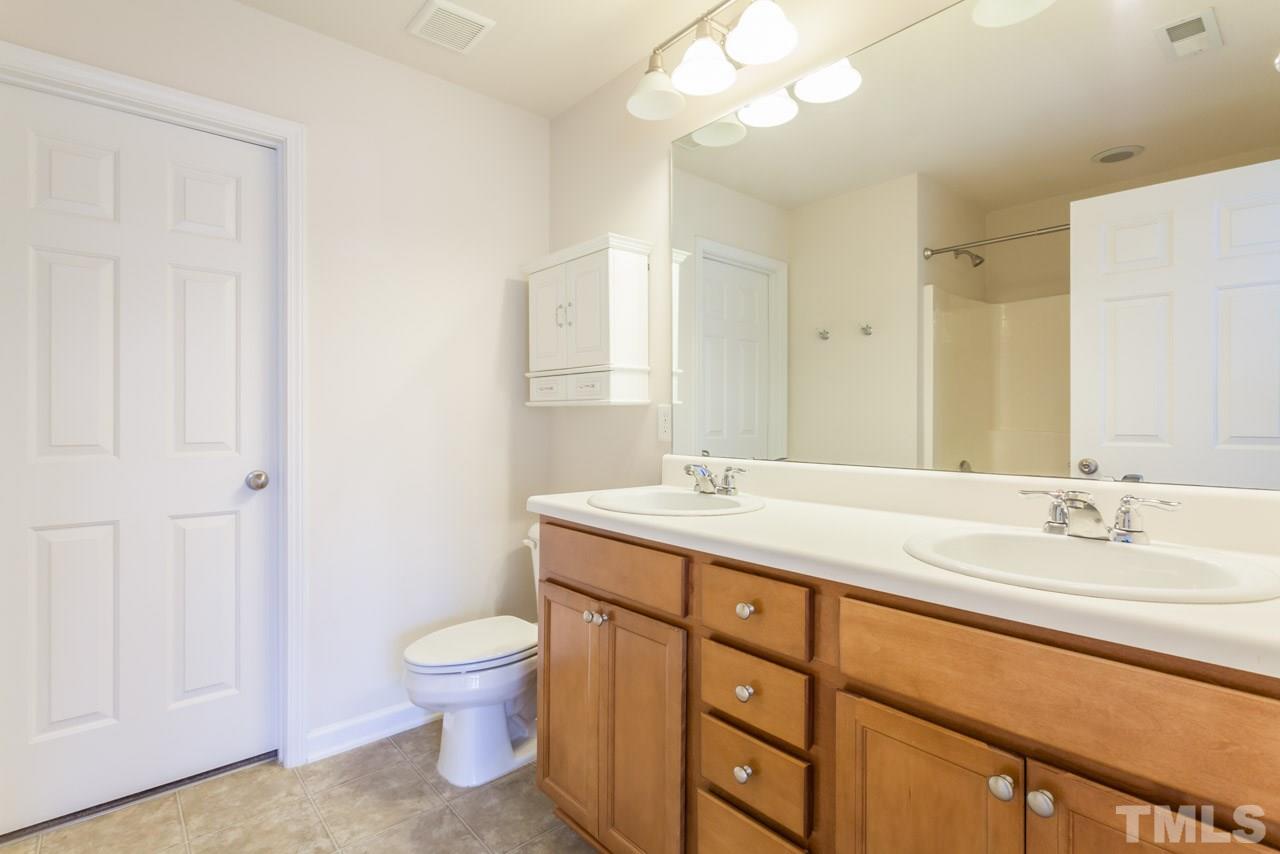 7006 Racine Way Raleigh, NC 27690 - Photo 10 of 24 a bathroom with a granite countertop sink a toilet and a mirror