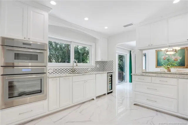 a kitchen with white cabinets and a stove