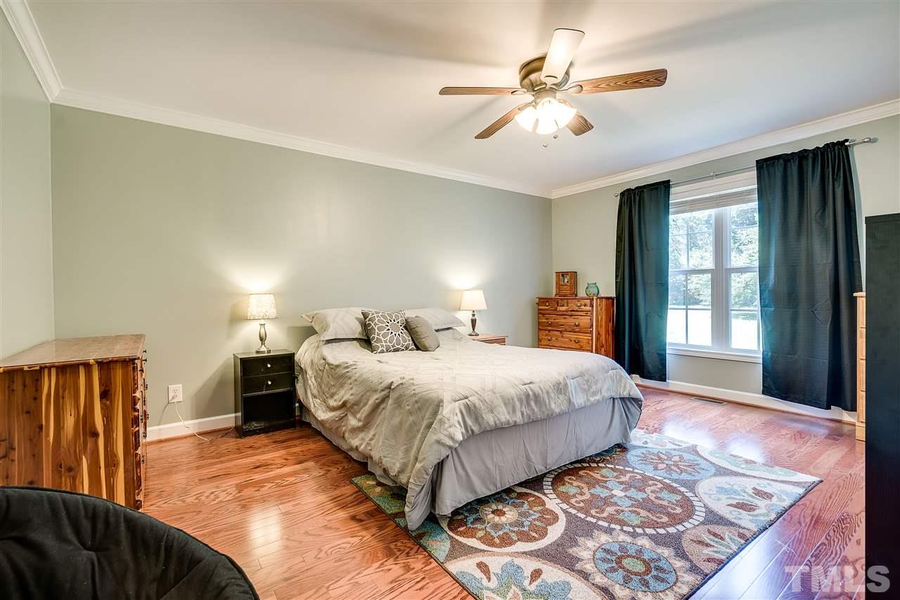 6008 East Pool Road Rougemont, NC 27572 - Photo 12 of 25 a bedroom with a large bed and a chandelier