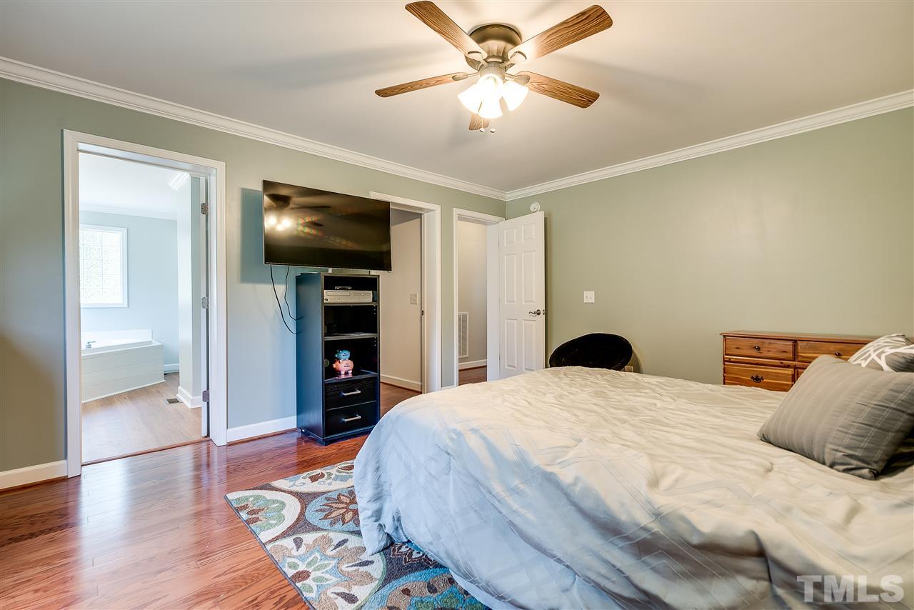 6008 East Pool Road Rougemont, NC 27572 - Photo 15 of 25 a bedroom with a bed and a chandelier