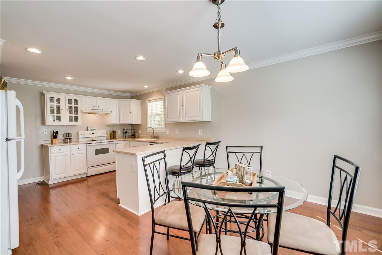 6008 East Pool Road Rougemont, NC 27572 - Photo 8 of 25 a kitchen with stainless steel appliances kitchen island granite countertop a dining table chairs and white cabinets