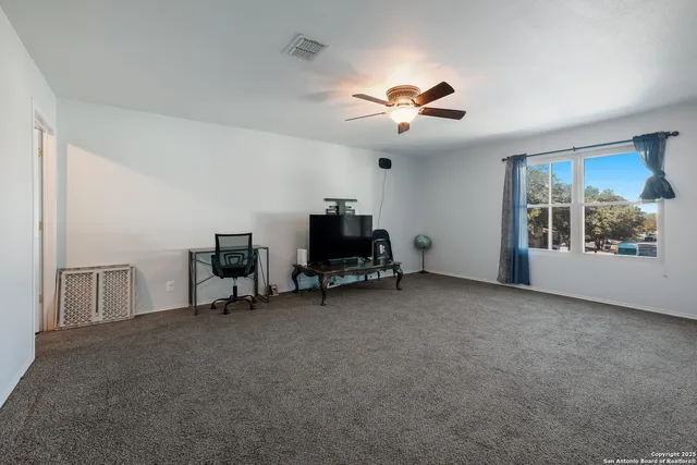 a view of a workspace with furniture and a window