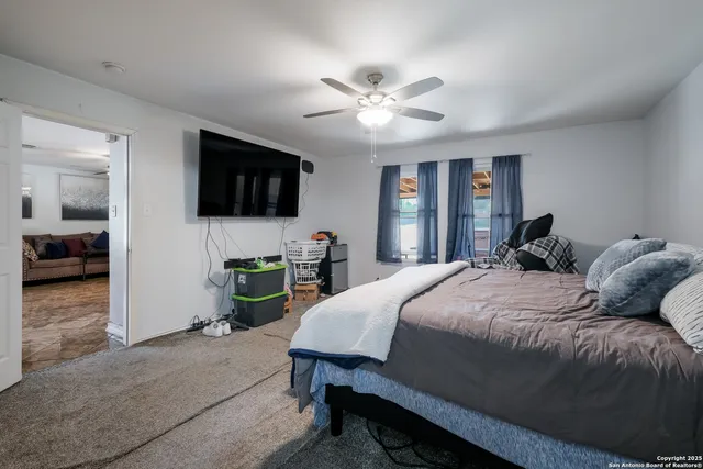 a bed room with a bed a television and a large window