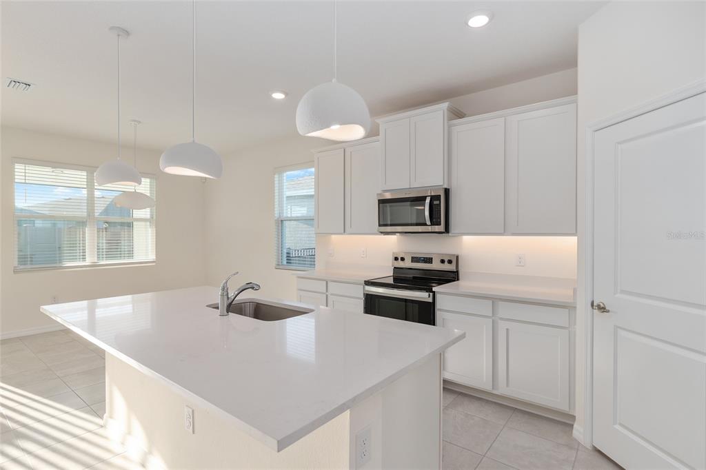 3972 Northwest 48th Terrace Ocala, FL 34482 - Photo 23 of 63 a kitchen with white cabinets and stainless steel appliances