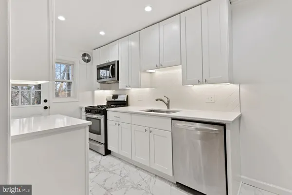 a kitchen with sink a microwave and cabinets
