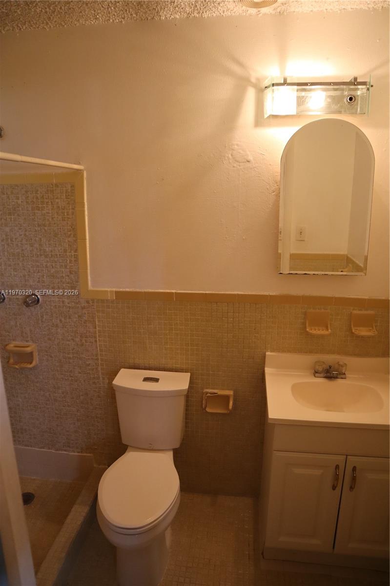 6514 Southwest 107th Place Miami, FL 33173 - Photo 11 of 18 a bathroom with a toilet sink and mirror
