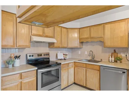 a kitchen with a sink a stove cabinets and a window