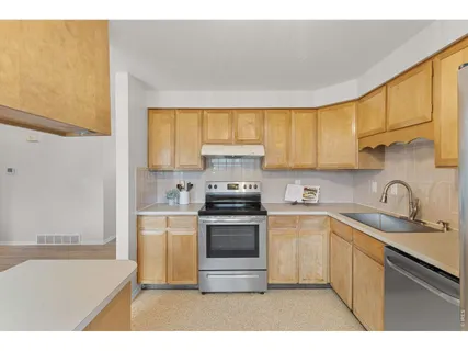a kitchen with a sink a stove and cabinets