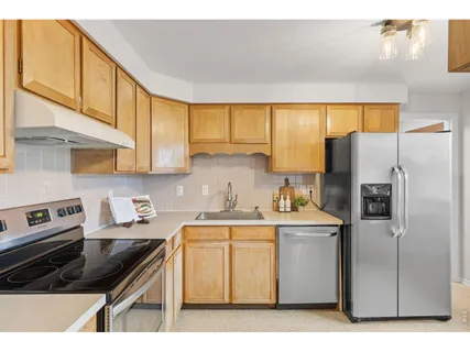 a kitchen with a sink a refrigerator and cabinets