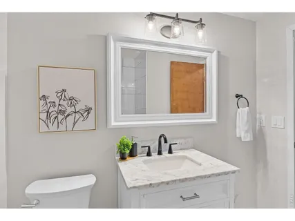 a bathroom with a toilet a sink and mirror
