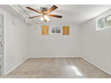 an empty room with wooden floor and ceiling fan