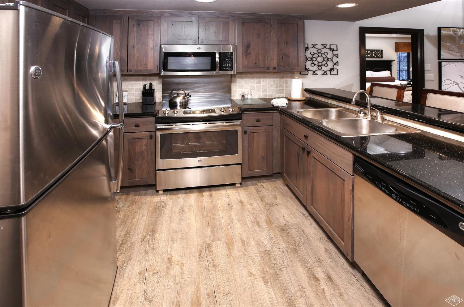 210 Offerson Road, Unit 209 WEEK 11 Beaver Creek, CO 81620 - Photo 4 of 37 a kitchen with stainless steel appliances granite countertop a sink stove microwave and refrigerator