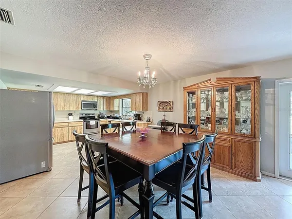 a view of a dining room and livingroom with furniture a rug and a painting