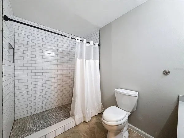 a white toilet sitting next to a shower curtain