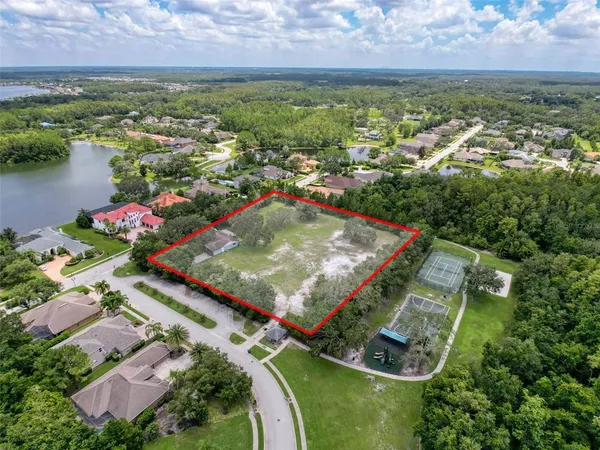 an aerial view of residential houses with outdoor space and lake view