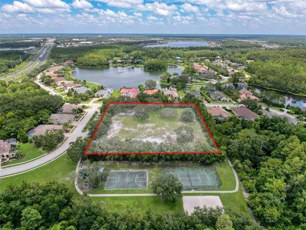 an aerial view of residential houses with outdoor space and lake view