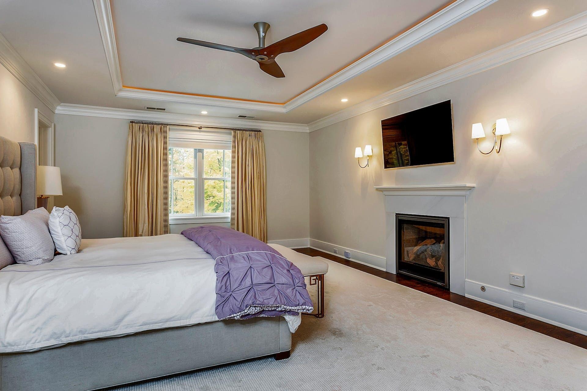 75 Parish Road New Canaan, CT 06840 - Photo 16 of 38 a bedroom with a large bed and a fireplace