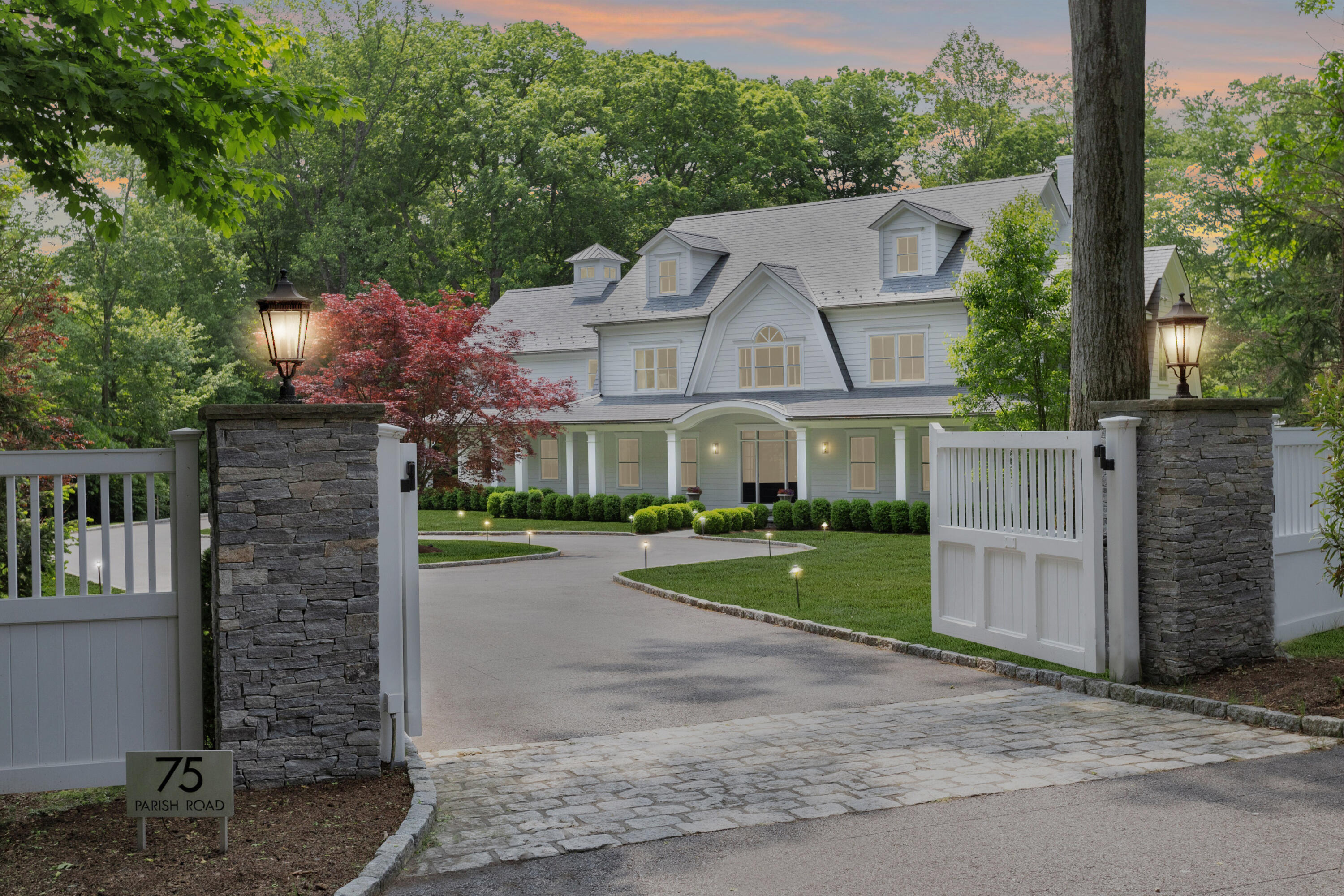 75 Parish Road New Canaan, CT 06840 - Photo 2 of 38 a front view of a house with a garden and yard
