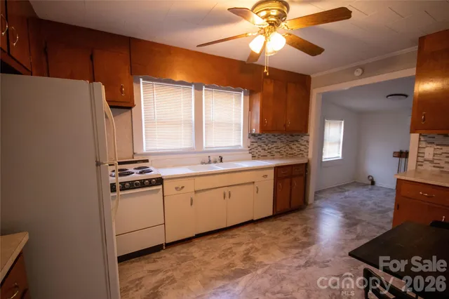 a kitchen with stainless steel appliances granite countertop a stove a sink dishwasher and a refrigerator