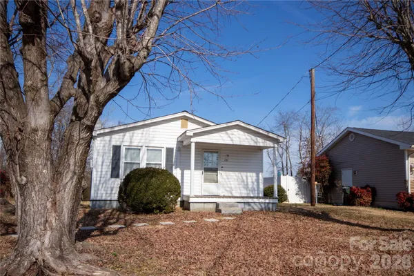 a view of a house with a backyard and a tree