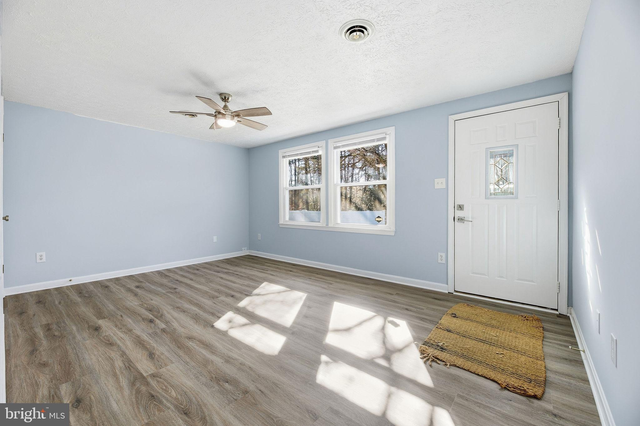 13108 Joy Road Lusby, MD 20657 - Photo 14 of 40 a view of empty room with wooden floor and fan