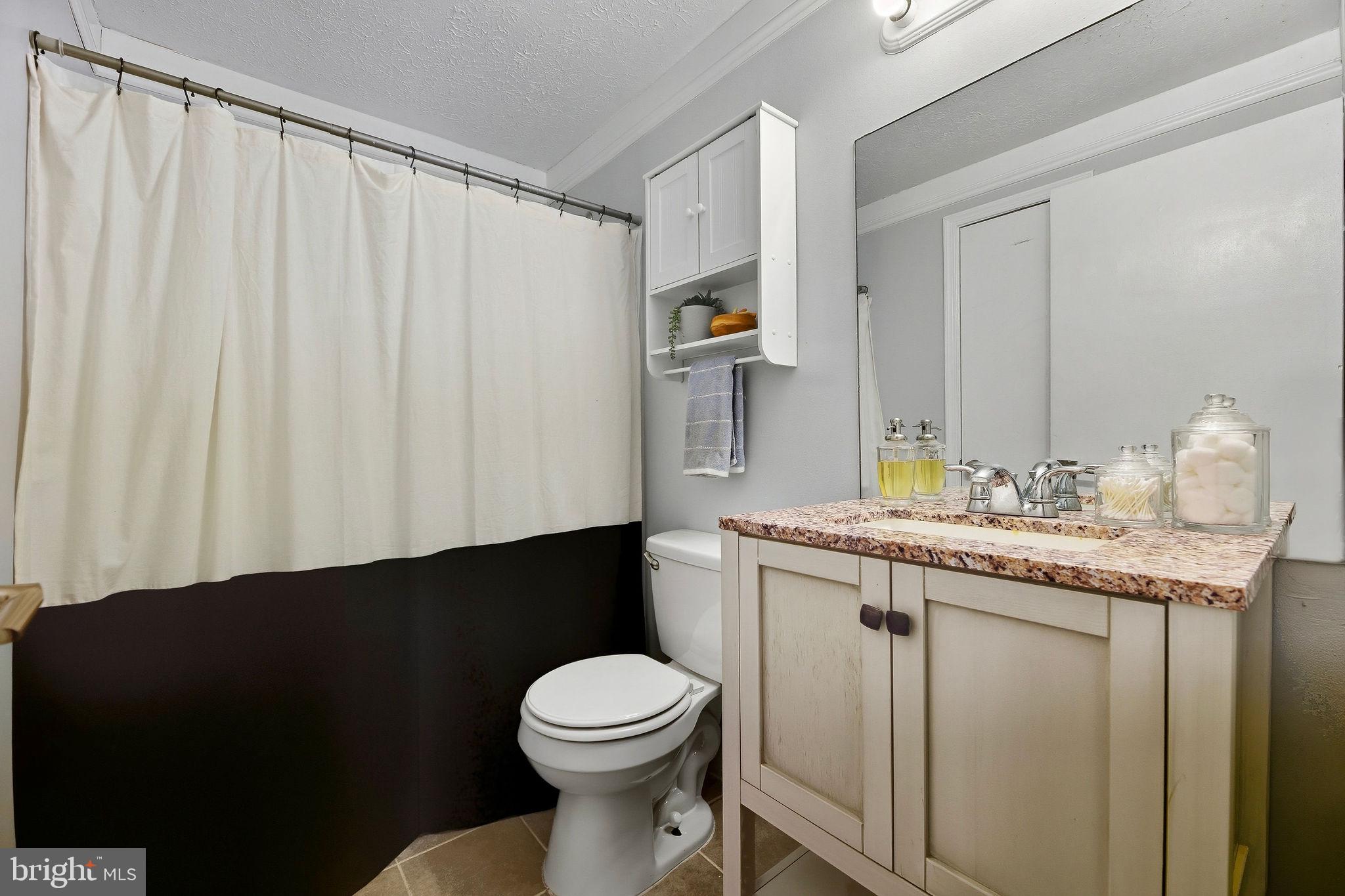 13108 Joy Road Lusby, MD 20657 - Photo 17 of 40 a bathroom with a granite countertop sink toilet and mirror
