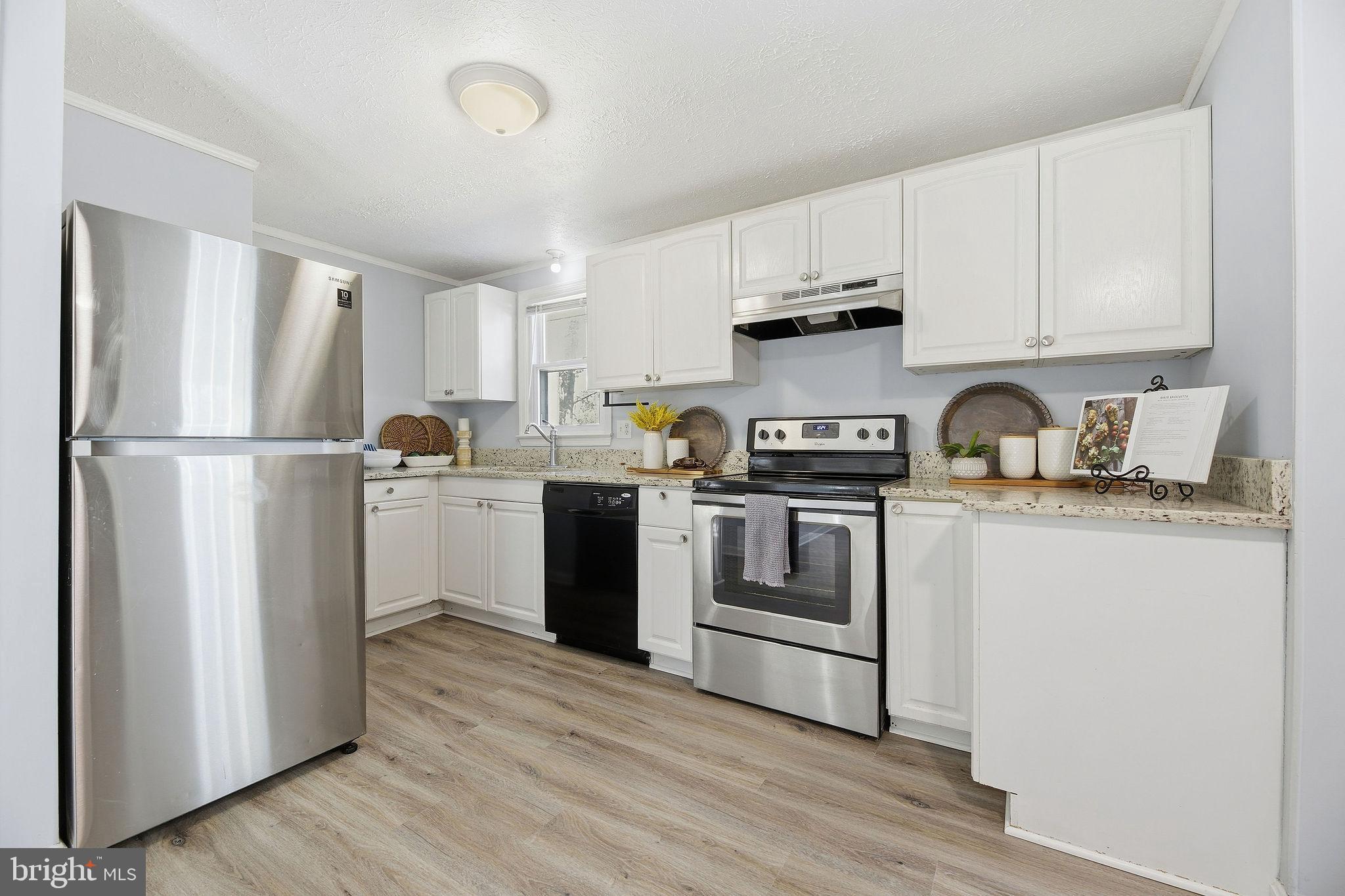 13108 Joy Road Lusby, MD 20657 - Photo 3 of 40 a kitchen with white cabinets and stainless steel appliances
