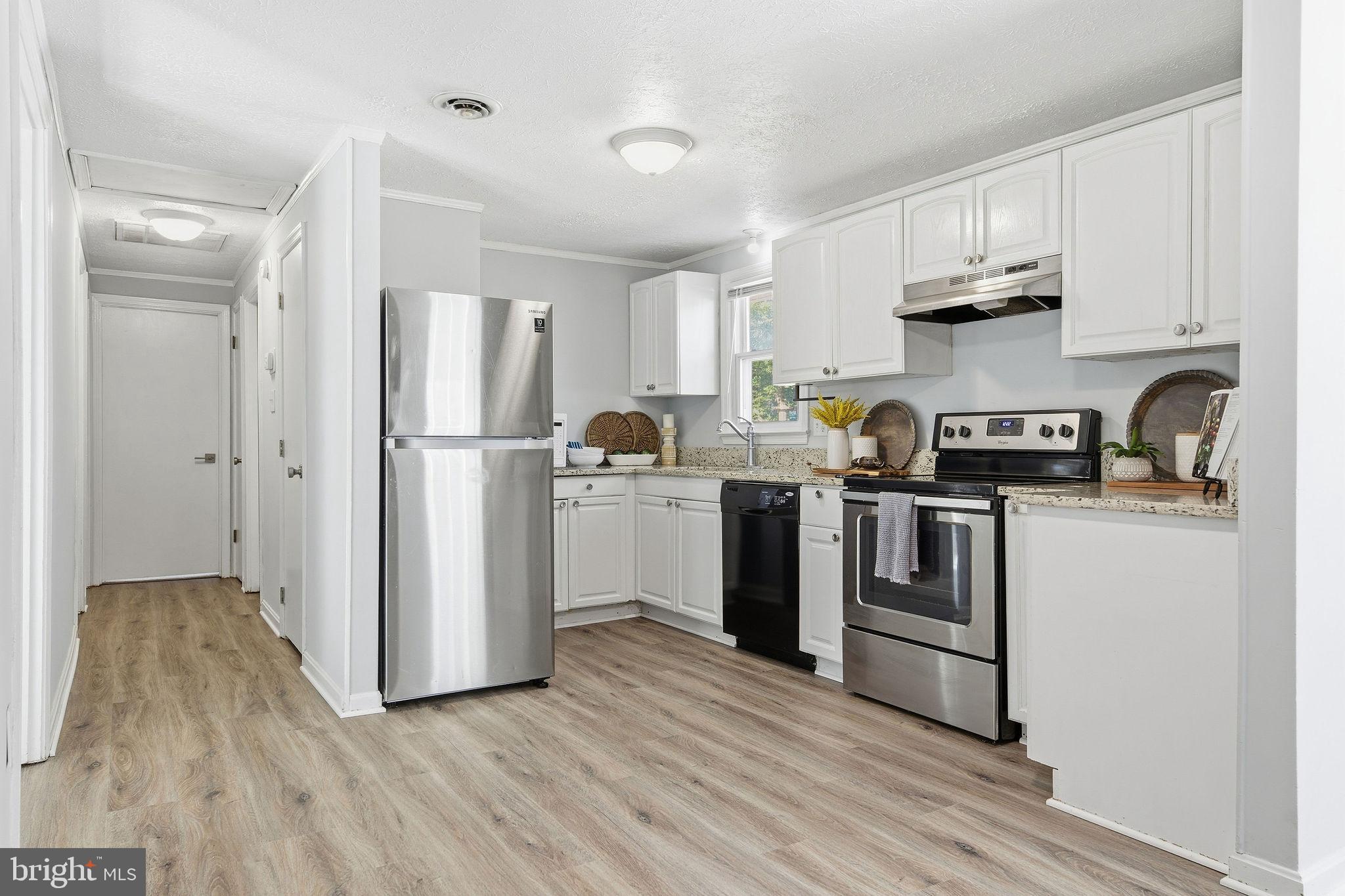 13108 Joy Road Lusby, MD 20657 - Photo 4 of 40 a kitchen with stainless steel appliances granite countertop a refrigerator sink and white cabinets