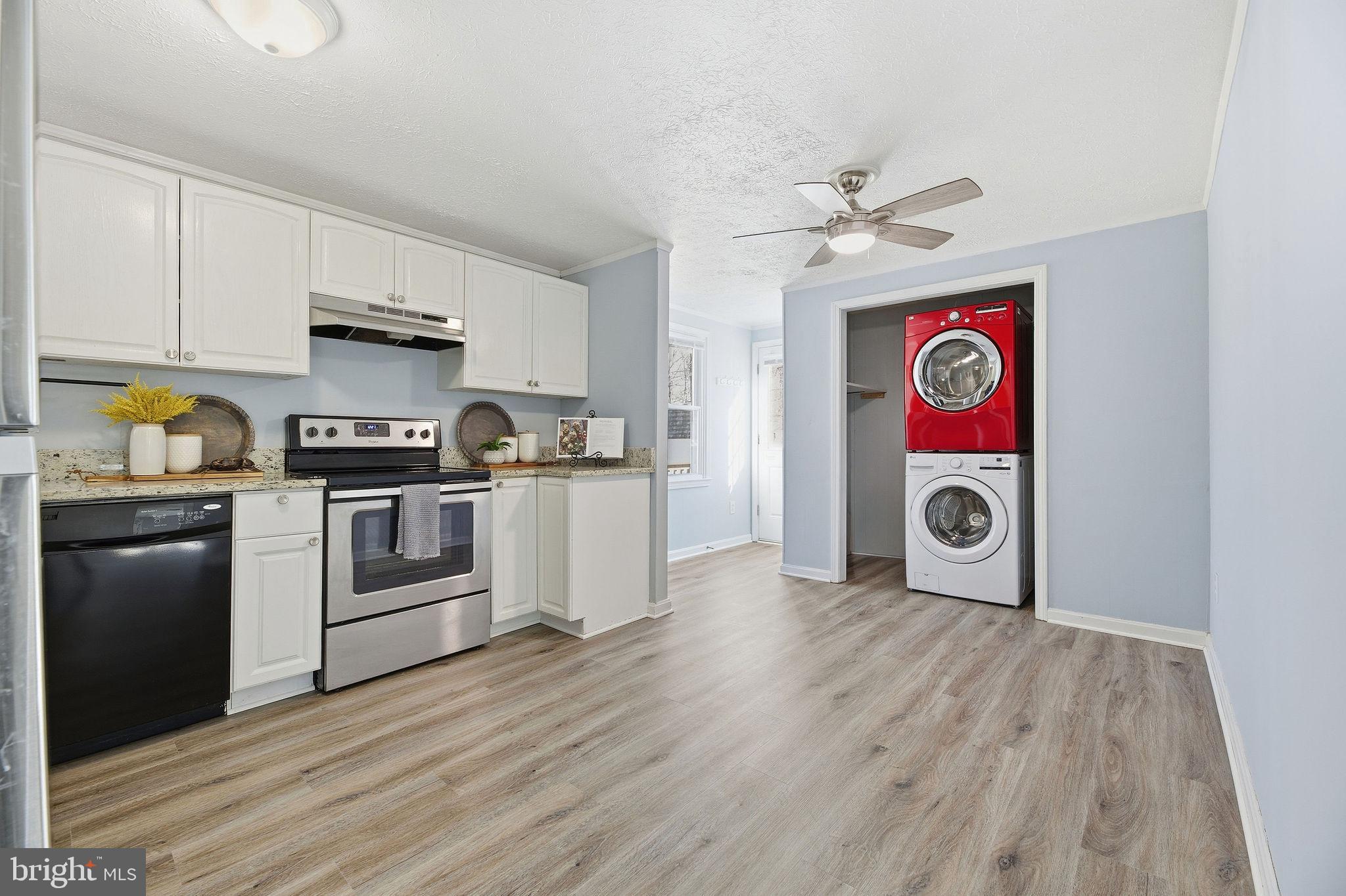 13108 Joy Road Lusby, MD 20657 - Photo 7 of 40 a kitchen with stainless steel appliances granite countertop a refrigerator a stove top oven a sink and dishwasher with wooden floor