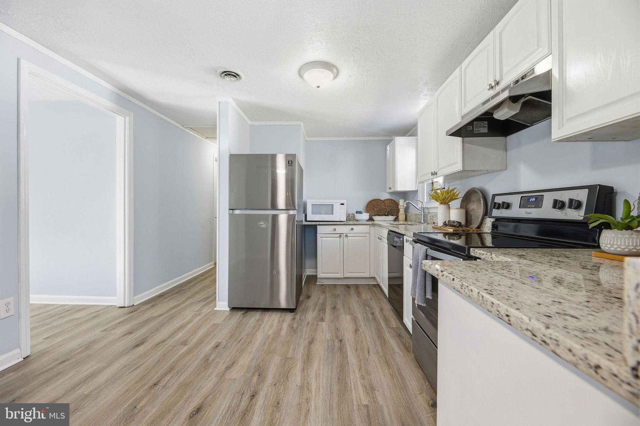 13108 Joy Road Lusby, MD 20657 - Photo 10 of 40 a kitchen with a refrigerator sink and wooden cabinets