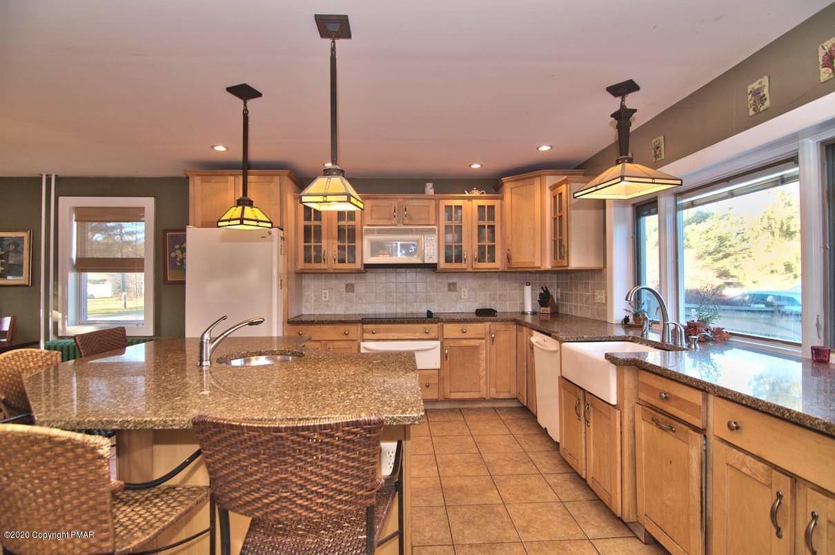 526 Weir Mountain Road Gilbert, PA 18331 - Photo 11 of 127 a kitchen with stainless steel appliances granite countertop a stove a sink and a refrigerator