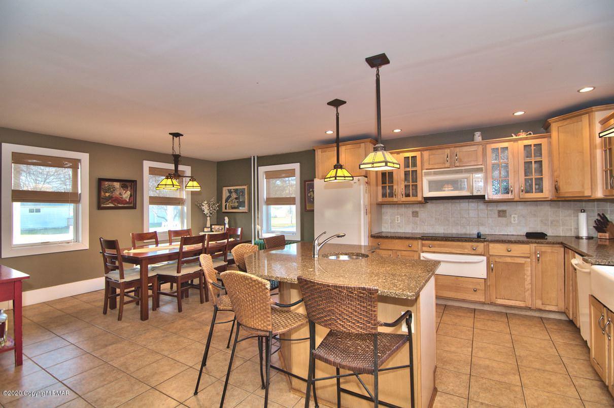 526 Weir Mountain Road Gilbert, PA 18331 - Photo 12 of 127 a dining hall with stainless steel appliances kitchen island granite countertop a table and chairs in it
