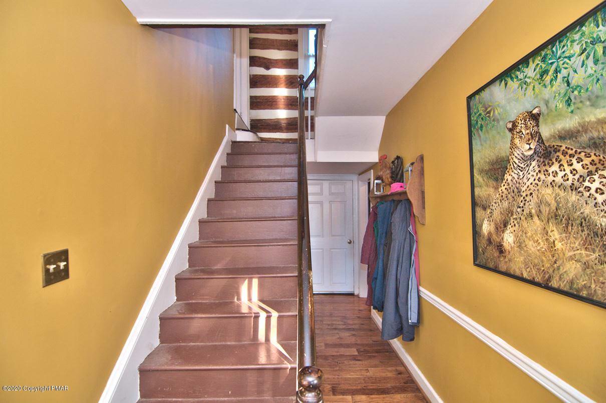526 Weir Mountain Road Gilbert, PA 18331 - Photo 31 of 127 a view of a staircase with wooden floor and a wall painting