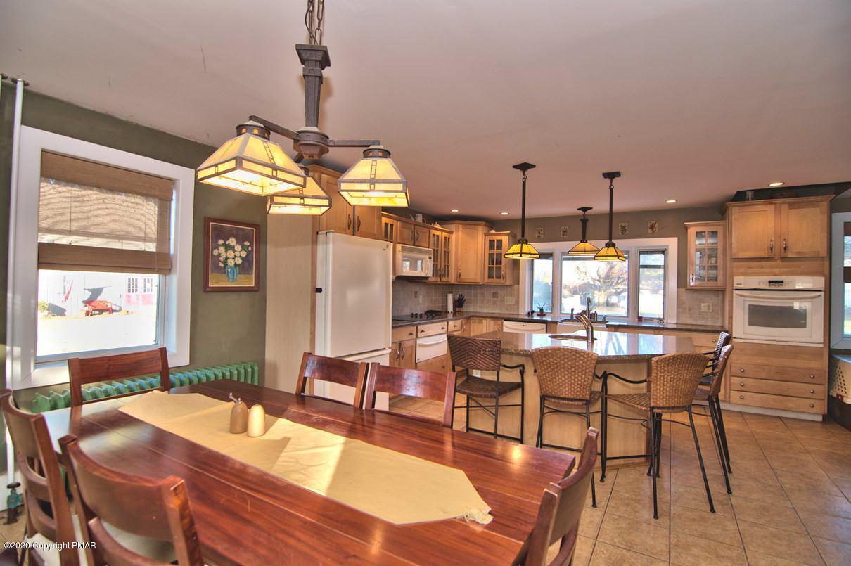526 Weir Mountain Road Gilbert, PA 18331 - Photo 4 of 127 a dining hall with stainless steel appliances kitchen island granite countertop a dining table chairs and window