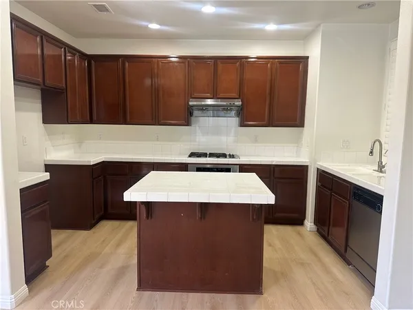 a kitchen with wooden cabinets a sink and a stove
