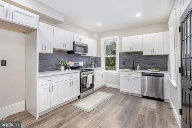 a kitchen with granite countertop white cabinets and white appliances