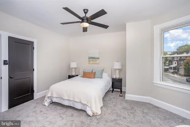 a bedroom with a bed and a large window